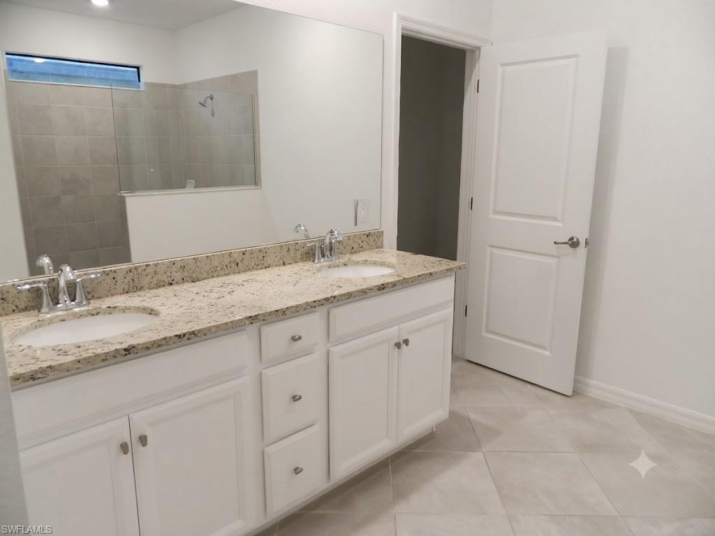 Dual vanity with light-colored speckled countertop, undermount sinks, and chrome faucets
