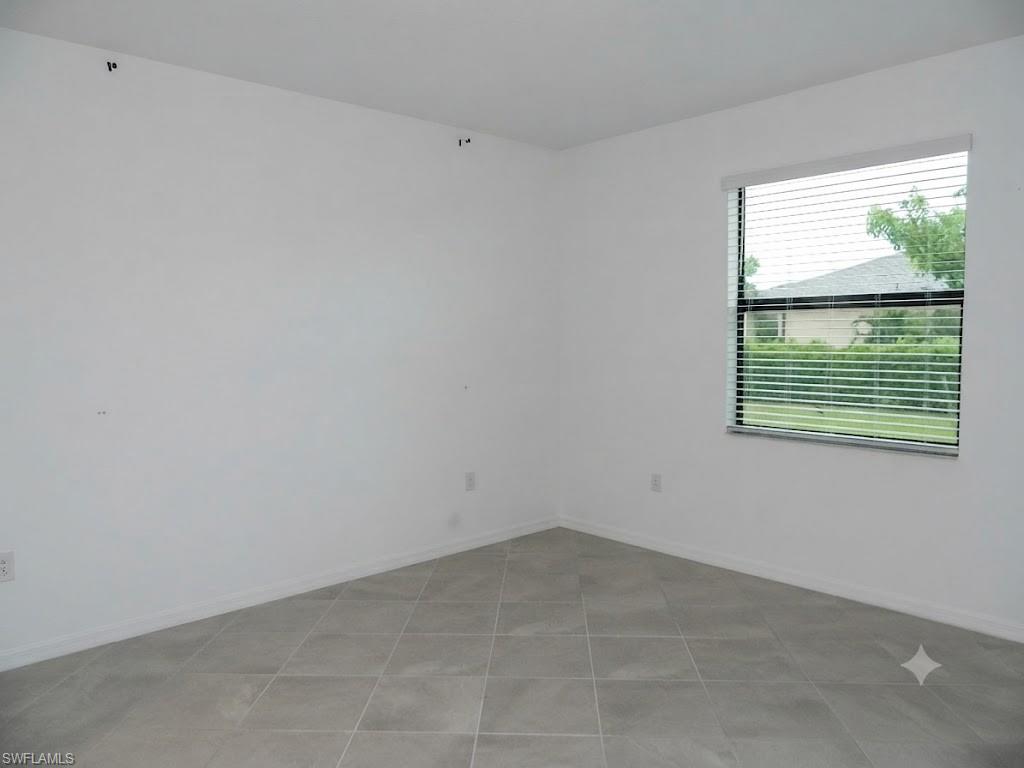 Room featuring tiled flooring, a single window with blinds, and white baseboards