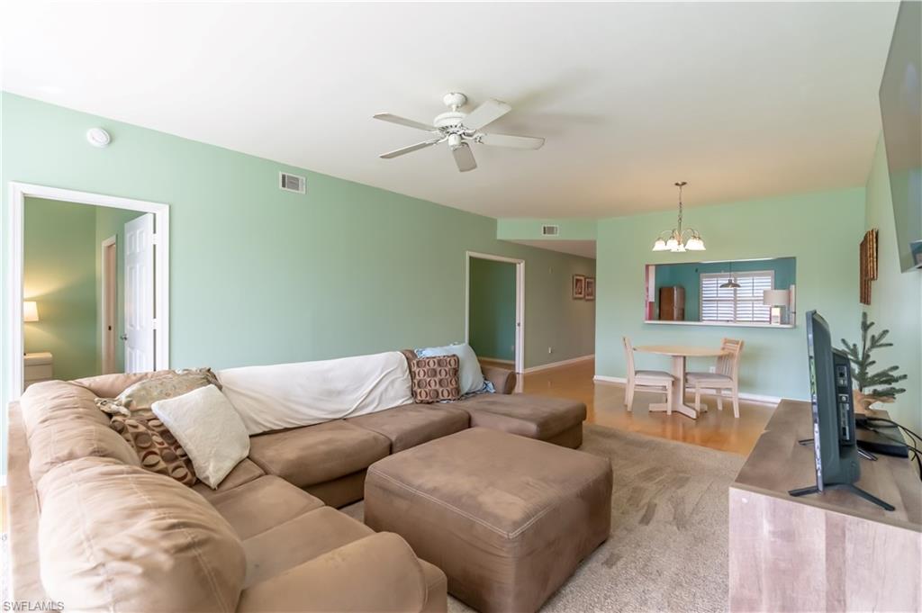 Living area with ceiling fan, recessed lighting, and pass-through window to dining space