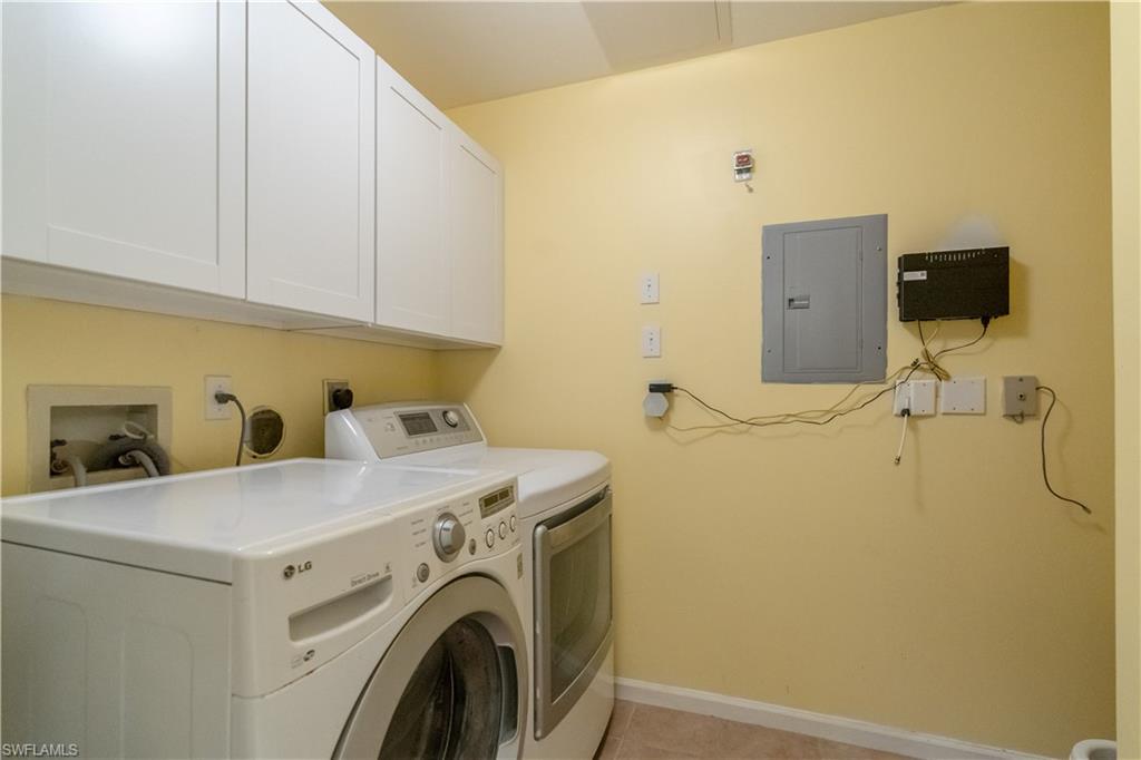 Laundry area featuring white upper cabinetry, electrical panel, and utility hookups