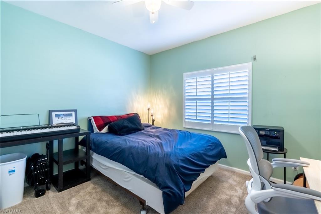 Wall-to-wall carpeting with a ceiling fan light fixture and a window with plantation shutters