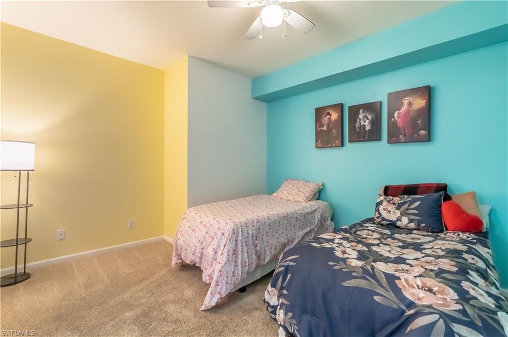 Light-colored wall-to-wall carpeting, ceiling fan, and painted walls