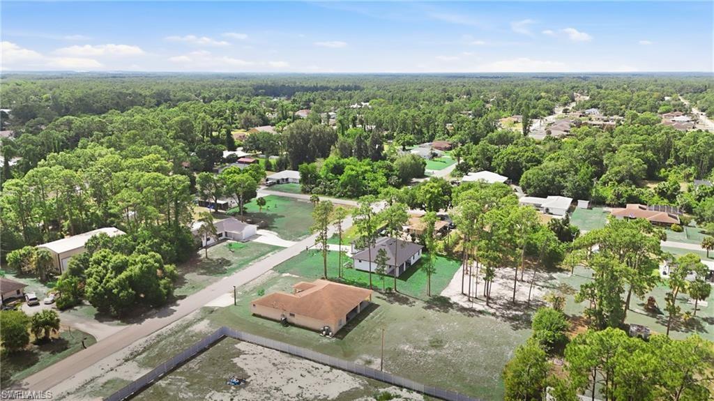Expansive lot offering ample space, surrounded by abundant mature trees, with a clear view of other properties and residential streets