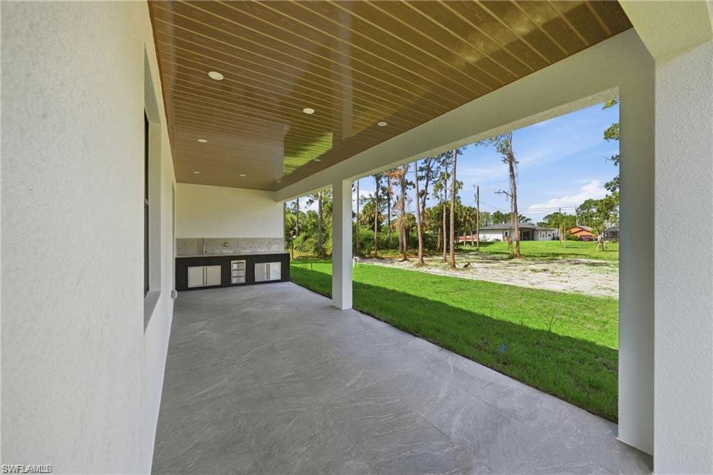 Covered patio with recessed lighting, wood-finish ceiling, and gray tile flooring