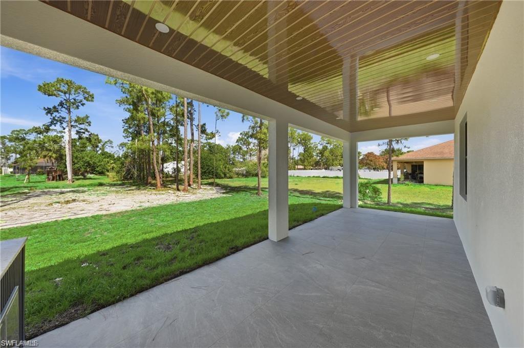 Expansive covered patio with a decorative ceiling, recessed lighting, and support columns