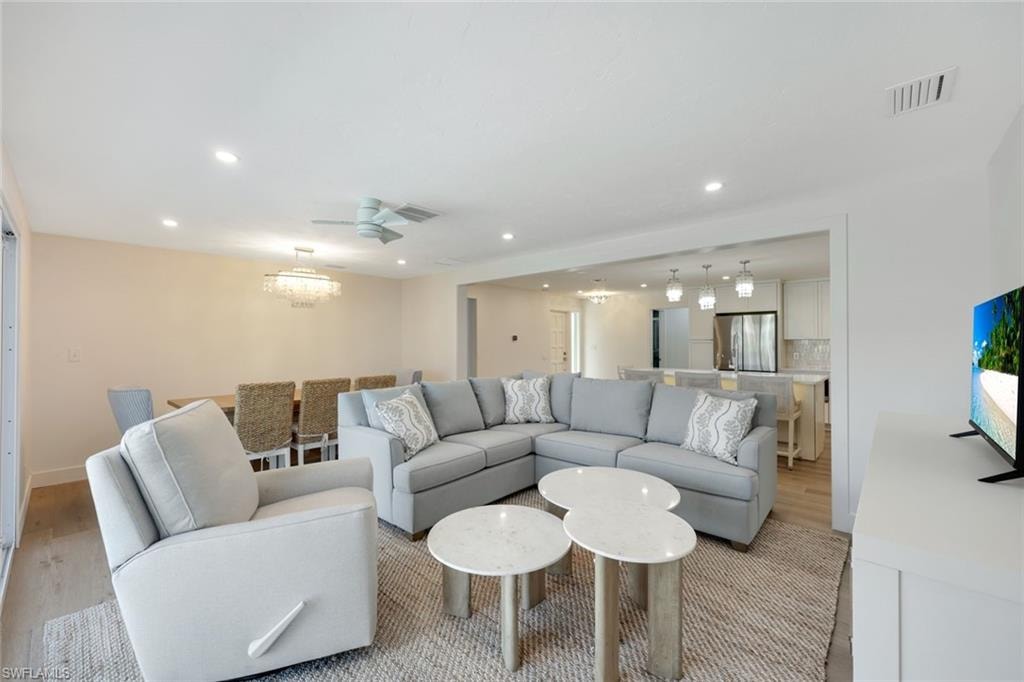 Open-concept living area with recessed lighting and wood-finish flooring