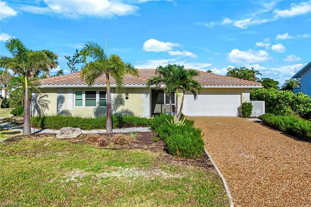 Single-story stucco residence featuring a tile roof and an attached garage