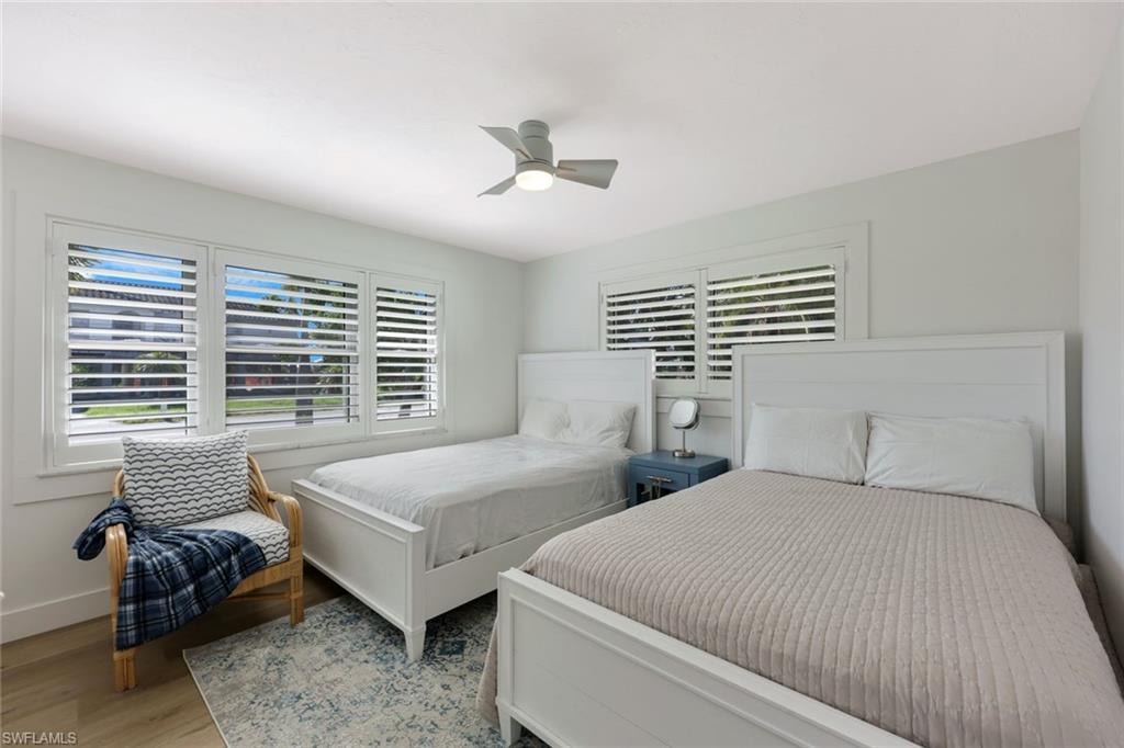 White walls and wood-finish flooring complement the extensive window array featuring white plantation shutters