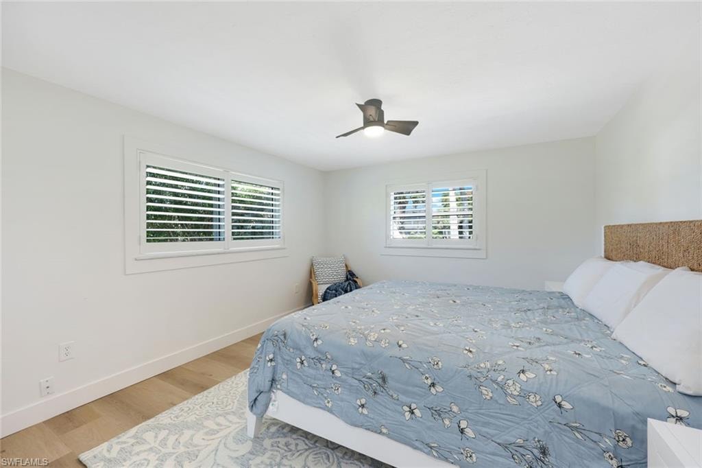 Room featuring light wood-finish flooring, white walls, and a contemporary ceiling fan