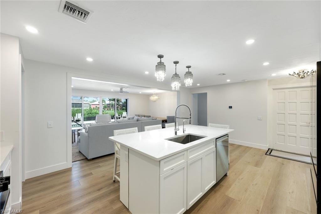 Spacious kitchen island featuring a stainless steel sink, contemporary faucet, and white countertop