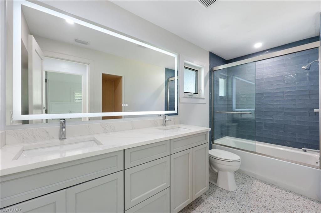 Bathroom featuring a dual vanity with light grey cabinetry and a white countertop