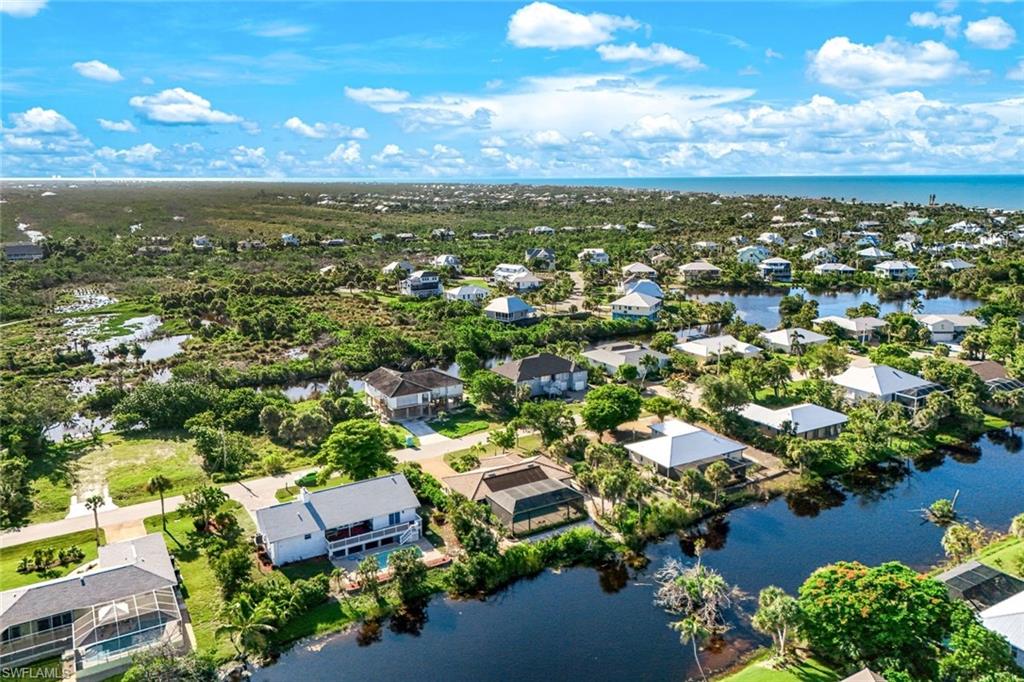 Coastal community featuring numerous properties with water frontage, lush green landscaping, and proximity to the ocean