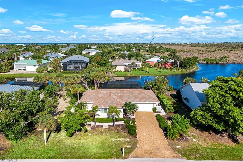 Single-story residence featuring a tile roof, an attached two-car garage, and a gravel driveway