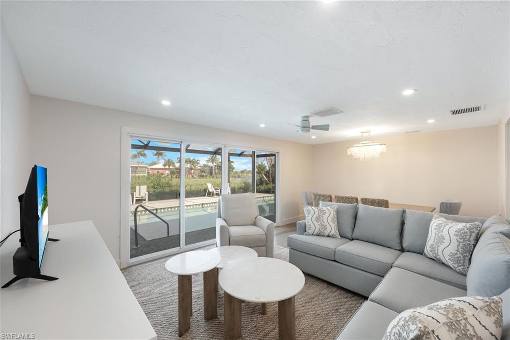 Spacious living area featuring recessed lighting, a ceiling fan, and a chandelier-style fixture