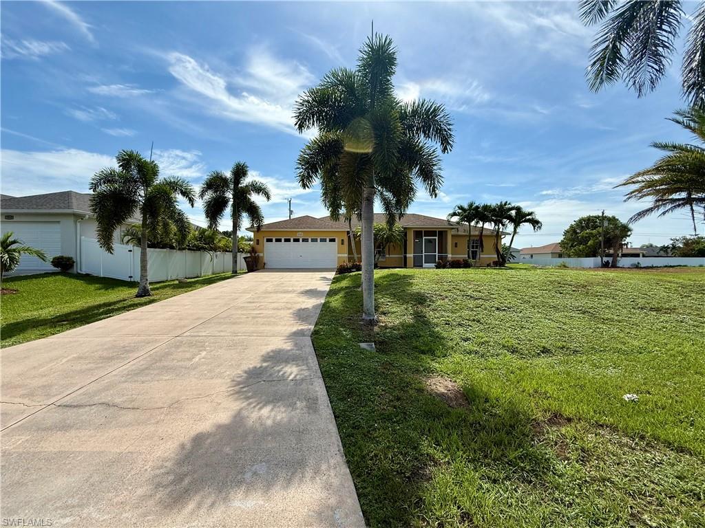 Single-story residence featuring a yellow exterior, white garage door, and screened front entry