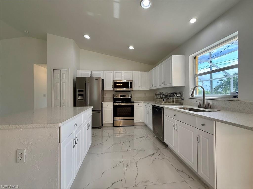 Contemporary kitchen featuring white cabinetry, light-toned countertops, and stainless steel appliances