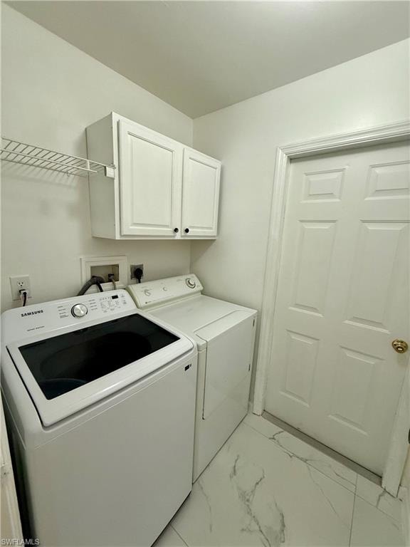 Dedicated laundry area featuring white upper cabinetry, wire shelving, and light-toned flooring with subtle veining