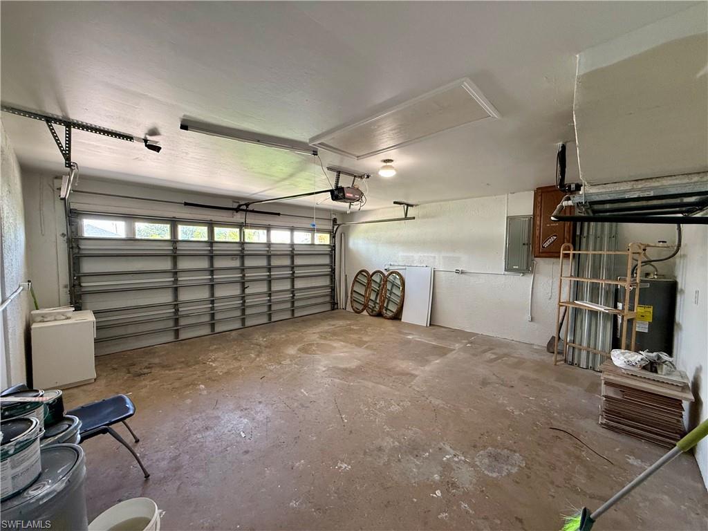 Spacious garage featuring a concrete floor, overhead lighting, and an automatic garage door opener