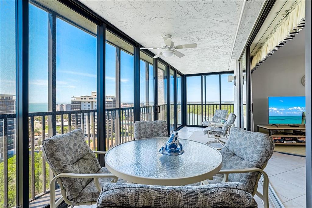 Enclosed balcony featuring floor-to-ceiling windows, a textured ceiling, and a ceiling fan