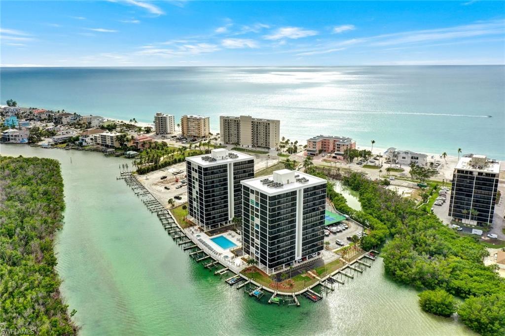Coastal high-rise buildings with balconies overlooking a waterway and the Gulf of Mexico