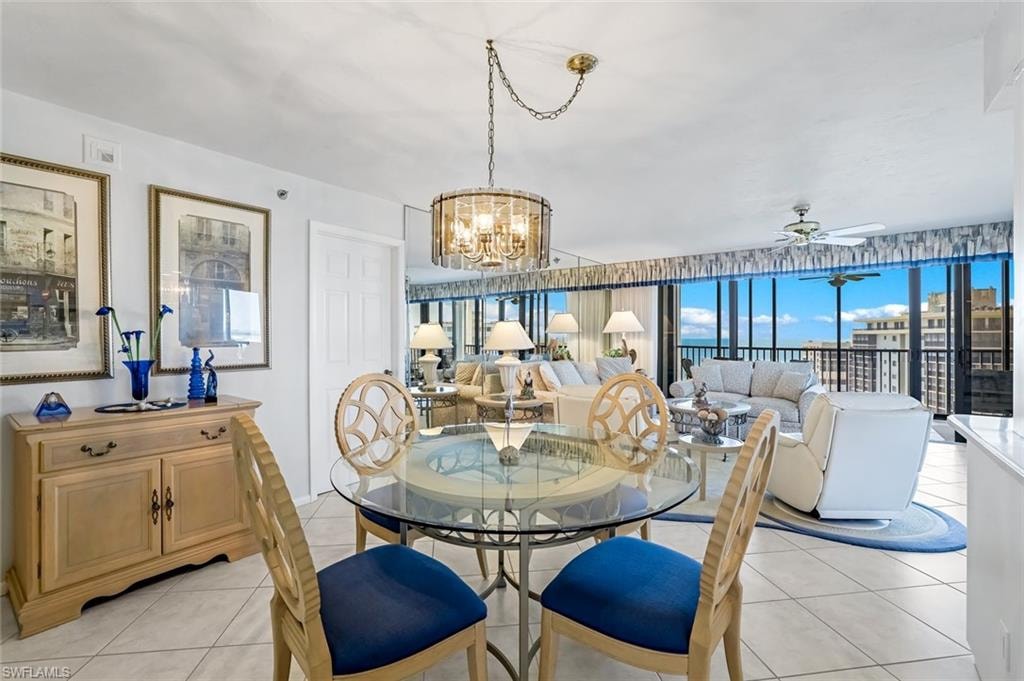 Dining area featuring a glass-top table, decorative chairs, and a chandelier with a polished brass chain