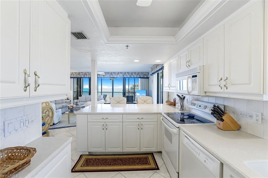 Bright kitchen featuring white cabinetry, light countertops, an electric cooktop, and a built-in microwave