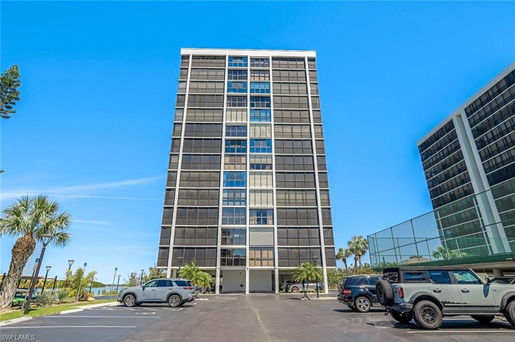 Modern high-rise residential building featuring a multi-story facade of dark-tinted windows