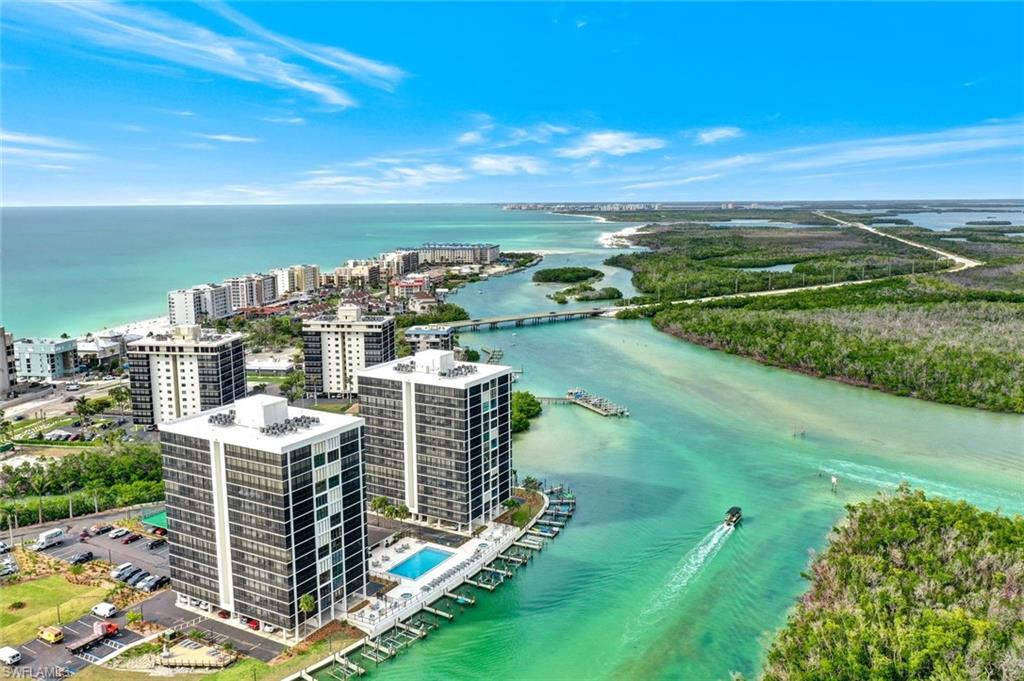 Coastal high-rise property featuring multiple buildings, a waterfront swimming pool, and private boat docks