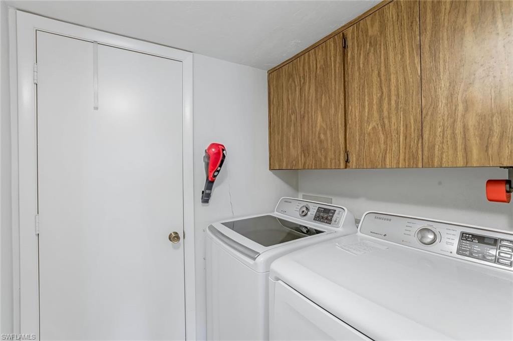 Integrated laundry area featuring wood-finish cabinetry and overhead storage