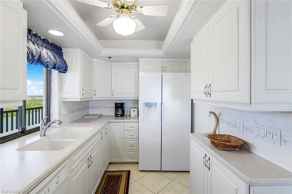 Bright kitchen featuring white cabinetry and appliances