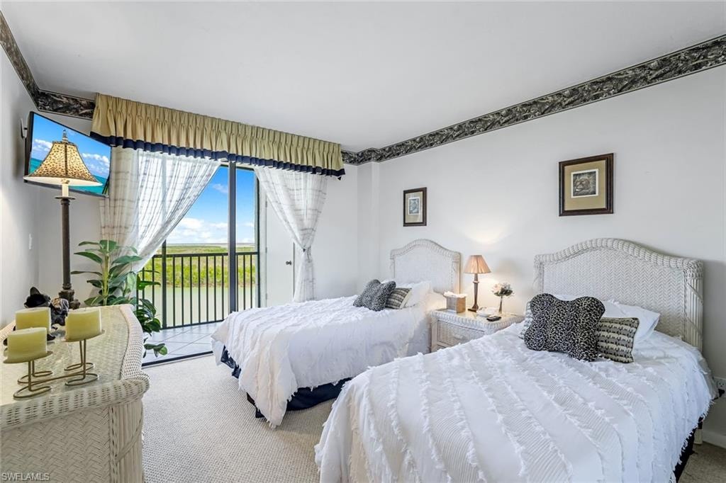 Room featuring a sliding glass door to a private balcony, white walls, and wall-to-wall carpeting