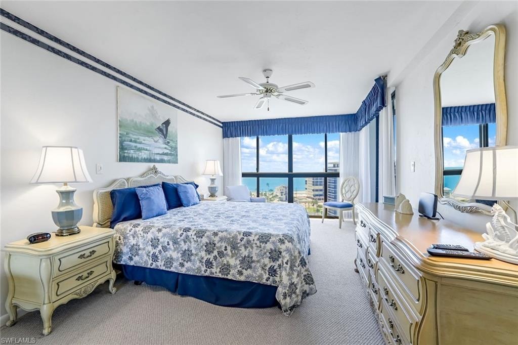 Bedroom with full-height windows, a ceiling fan, and carpeted flooring