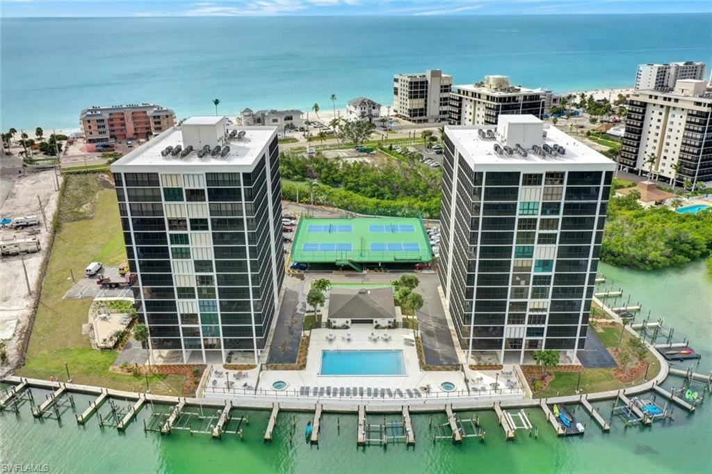 Dual high-rise residential buildings featuring waterfront access with private boat slips, an outdoor swimming pool, and a tennis court