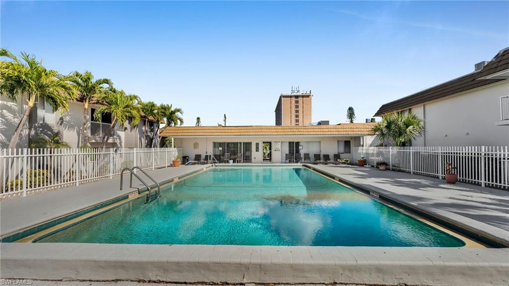 Rectangular swimming pool with a tiled edge, surrounded by a paved deck