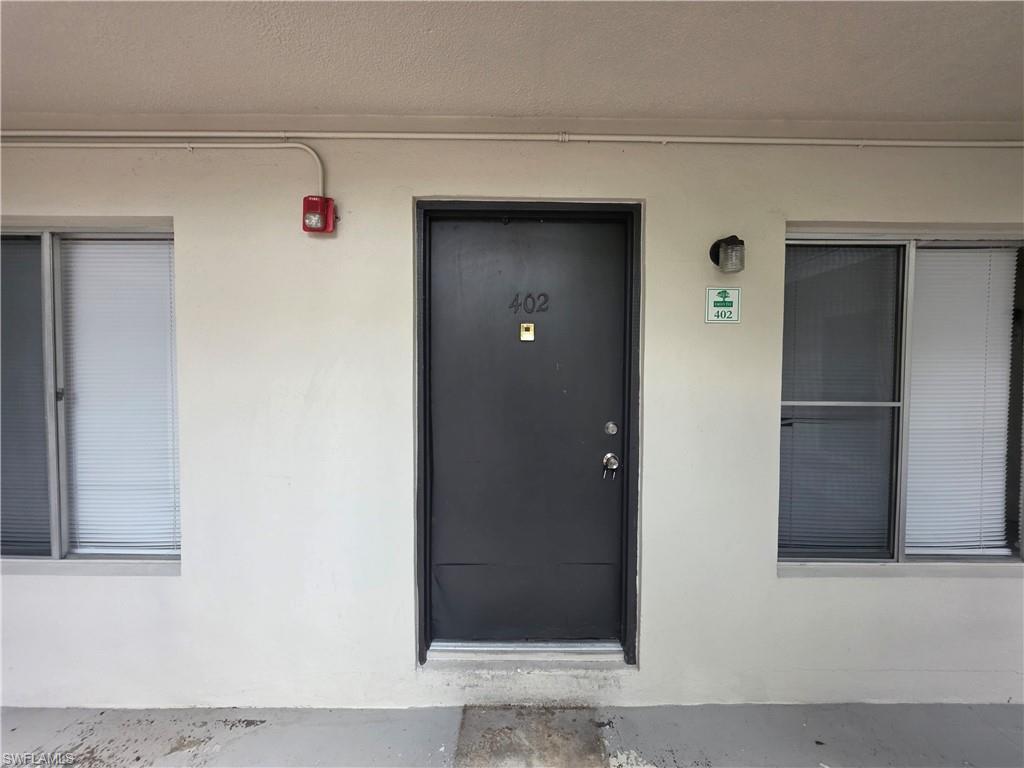 Unit 402 Entry featuring a solid black finished door with chrome hardware, recessed lighting, and direct access from the common corridor
