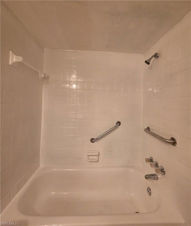Classic subway tile shower surround with dual showerheads, grab bars, and brushed nickel fixtures