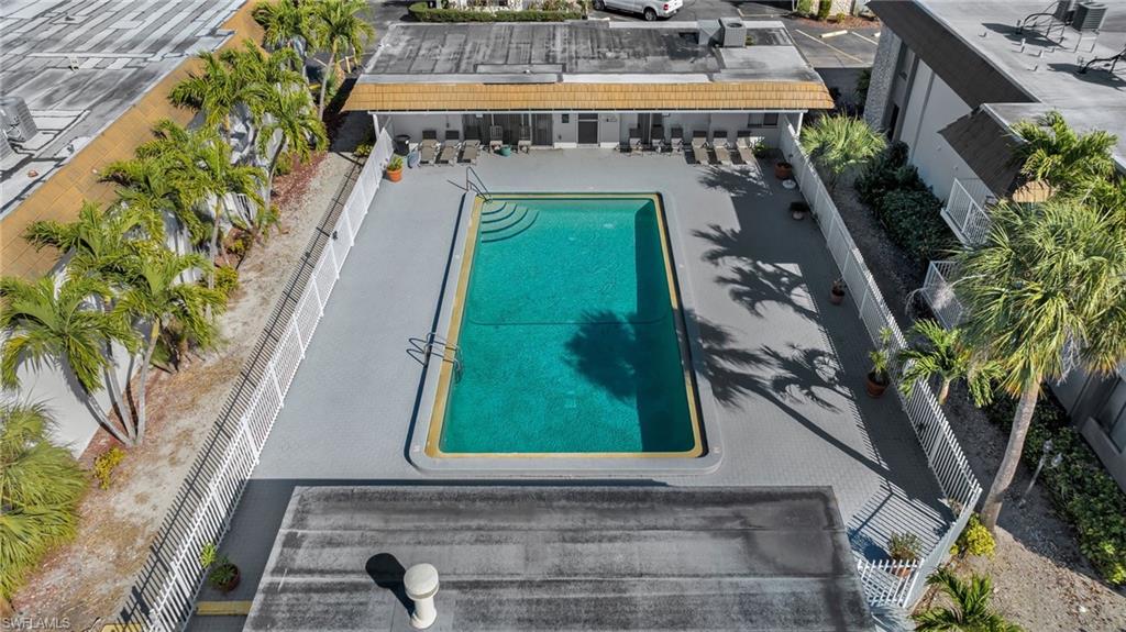 Outdoor swimming pool with integrated steps, surrounded by a light gray paver deck