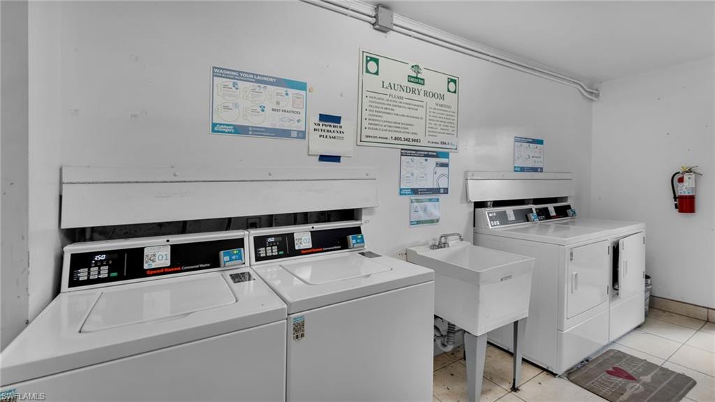 Dedicated laundry room featuring full-size front-load washer and dryer with overhead storage cabinetry, utility sink with faucet, and instructional signage
