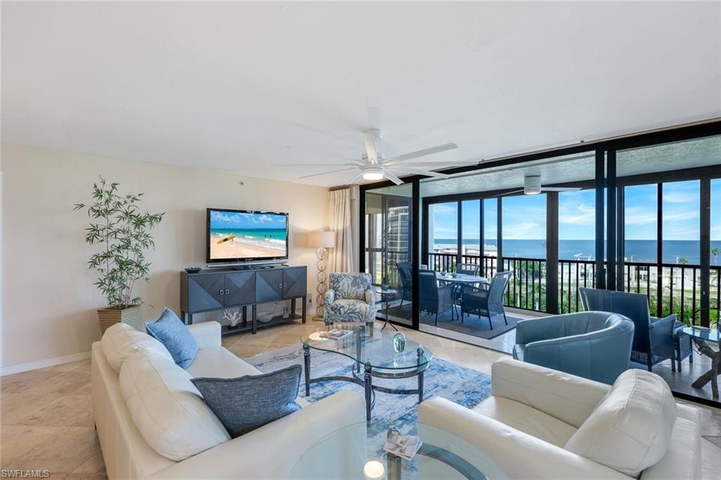 Spacious living area featuring expansive glass sliding doors opening to a balcony with ocean scenery