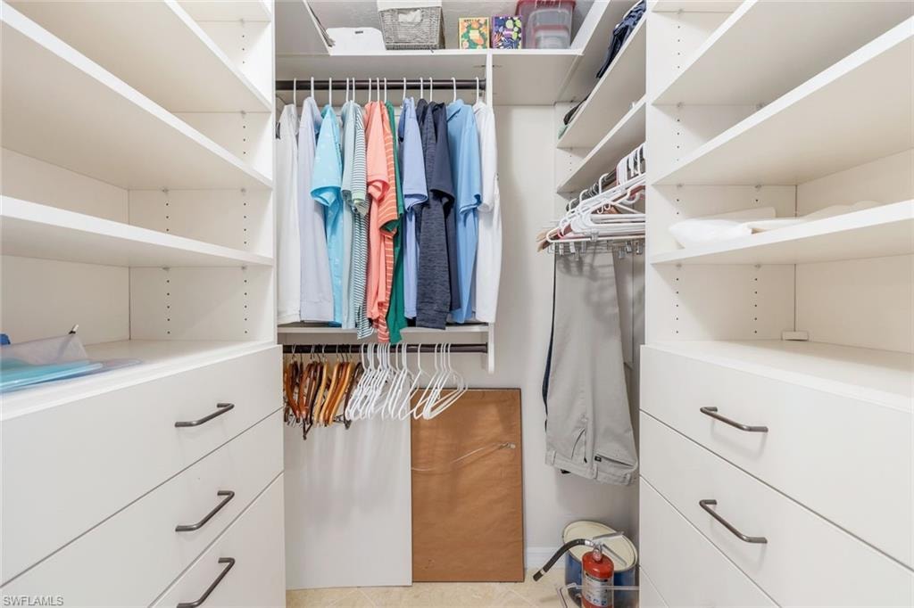 Custom closet system featuring white shelving and integrated drawers with dark hardware