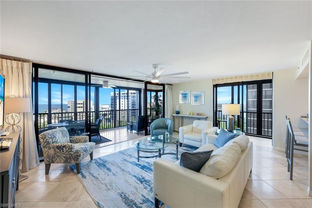 Spacious living area featuring large format tile flooring and extensive floor-to-ceiling glass doors opening onto a private balcony