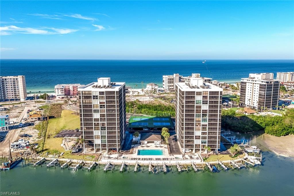 Waterfront high-rise community featuring two residential towers, a large swimming pool, tennis court, and multiple boat slips