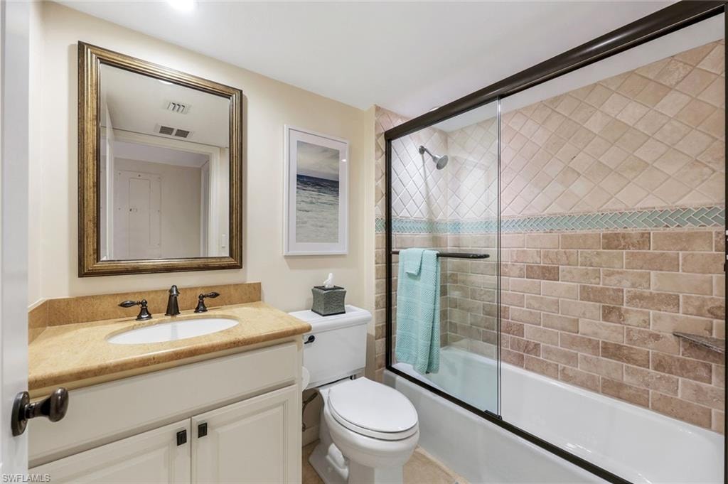 Bathroom featuring a vanity with an undermount sink, a countertop, and a framed mirror