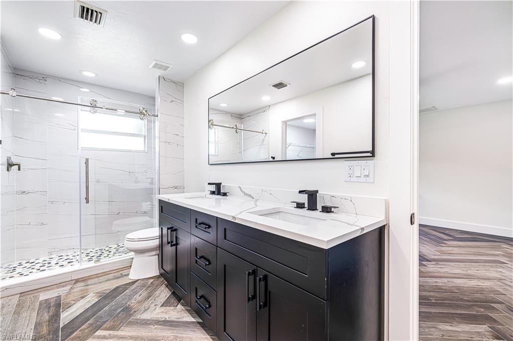 Gorgeous bathroom featuring dual vanity with a white countertop and black cabinetry. Stunning!