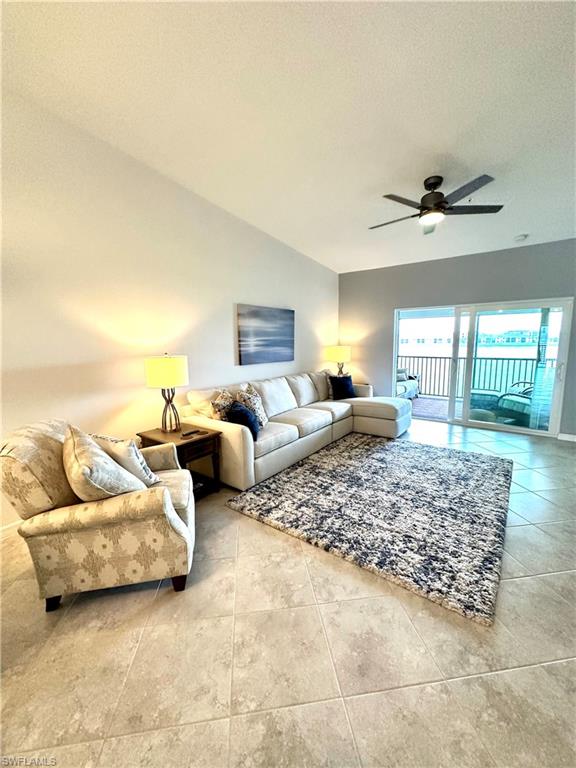 Tiled living room with ceiling fan and a textured ceiling