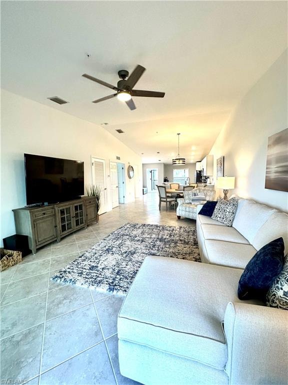Tiled living room with lofted ceiling and ceiling fan
