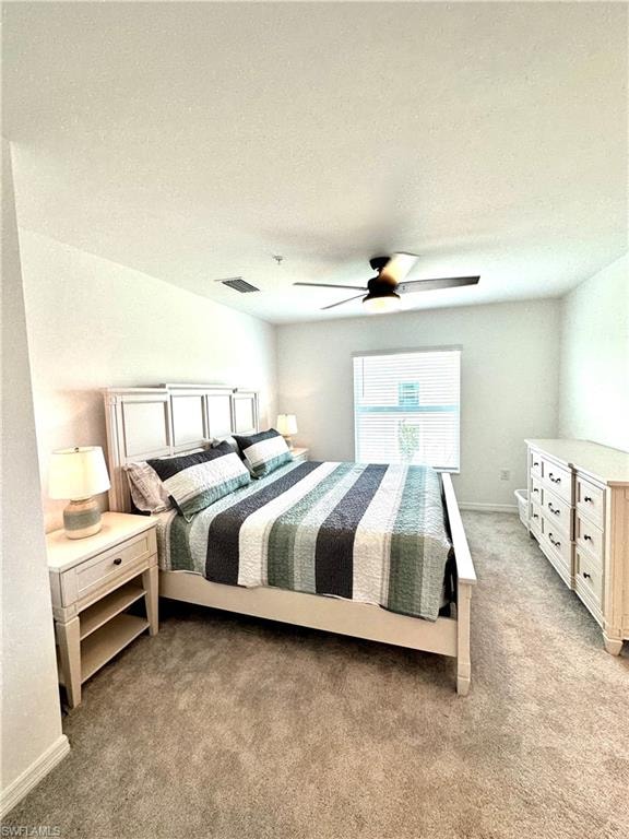 Bedroom with a textured ceiling, carpet, and ceiling fan