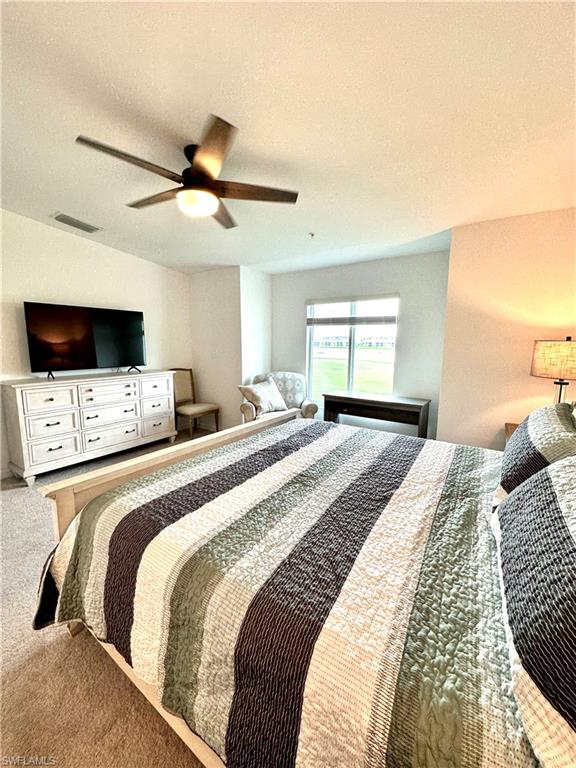 Carpeted bedroom with a textured ceiling and ceiling fan