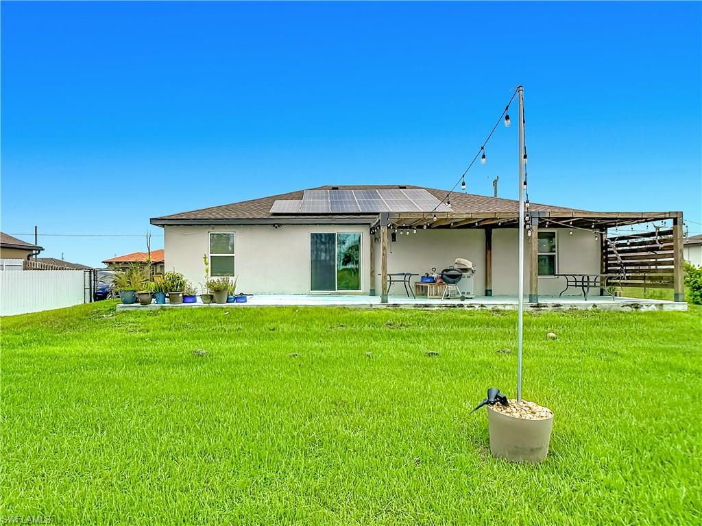 Expansive green lawn with a white privacy fence