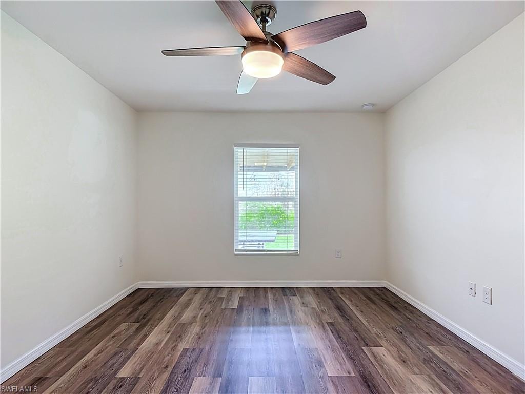 Room featuring wood-finish flooring, a ceiling fan with integrated lighting, a window with horizontal blinds, and neutral wall finishes